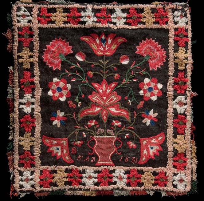 Quite a rich selection of early 19th century woollen embroideries, double interlocked tapestries and other art-woven decorative interior textiles are preserved from the close-by districts of Oxie and Bara. Usually these textiles were produced by well-to-do farmers’ wives/daughters and not in the city itself. This well-preserved seat cushion from Hötofta village in Oxie district was marked and dated “KAD 1831”. A weft ribbed fabric – linen warp and woollen weft – with a voided pile weave border, woollen embroidery and a so-called “Kavelfrans” or napped edgings. (Courtesy of: Nordic Museum, Stockholm, NM.0020235. Digitalt Museum). 