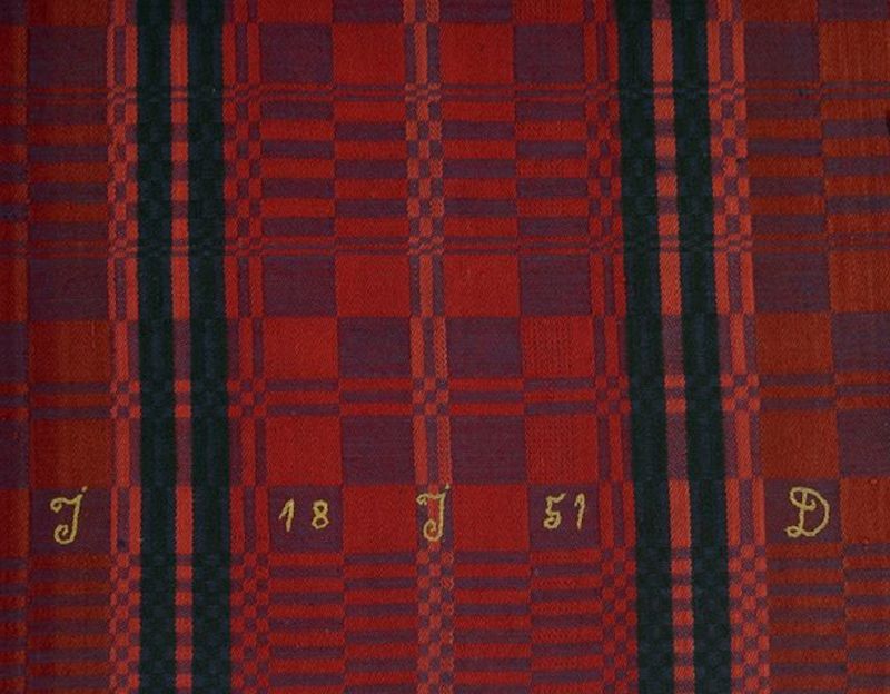 Despite the increasing textile industry with machine woven qualities, the hand weaving continued side by side during many years in the area, though with decreasing importance. This colourful bedcover of cotton warp and woollen weft is one evident example. The interior textile was produced in a home environment and clearly marked “1851” and the initials “JJD” in chain-stitch with silk thread. The unknown female weaver lived in the then rural area Östra Skrävlinge, which today is part of Malmö. (Courtesy of: Malmö Museum, No: MM 003638, detail of bedcover, 178cm x 134 cm).