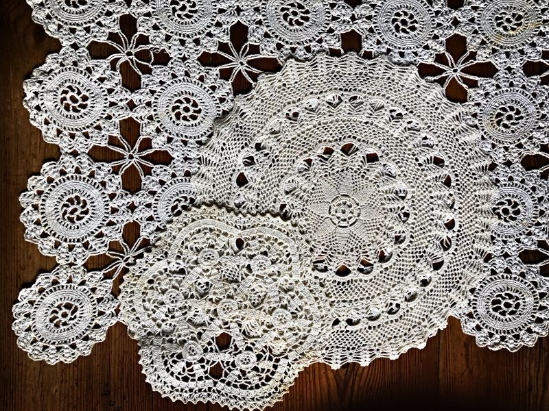 Even if crochet edges are more visible in early photographs than tablecloths in the same technique, the latter seems to have been just as in vogue and illustrated with three examples. The two small circle-shaped models were worked from the centre and outwards, round and round to the desired size – the motif combinations were almost endless. The larger model, partly illustrated, was instead crocheted in many small circles of the same design and then stitched and crocheted together – with a spindle-shaped motif – when the acquired amount of small circles had been made. This particular tablecloth has five times seven (35) circles. (Private ownership). Photo: Viveka Hansen, The IK Foundation.